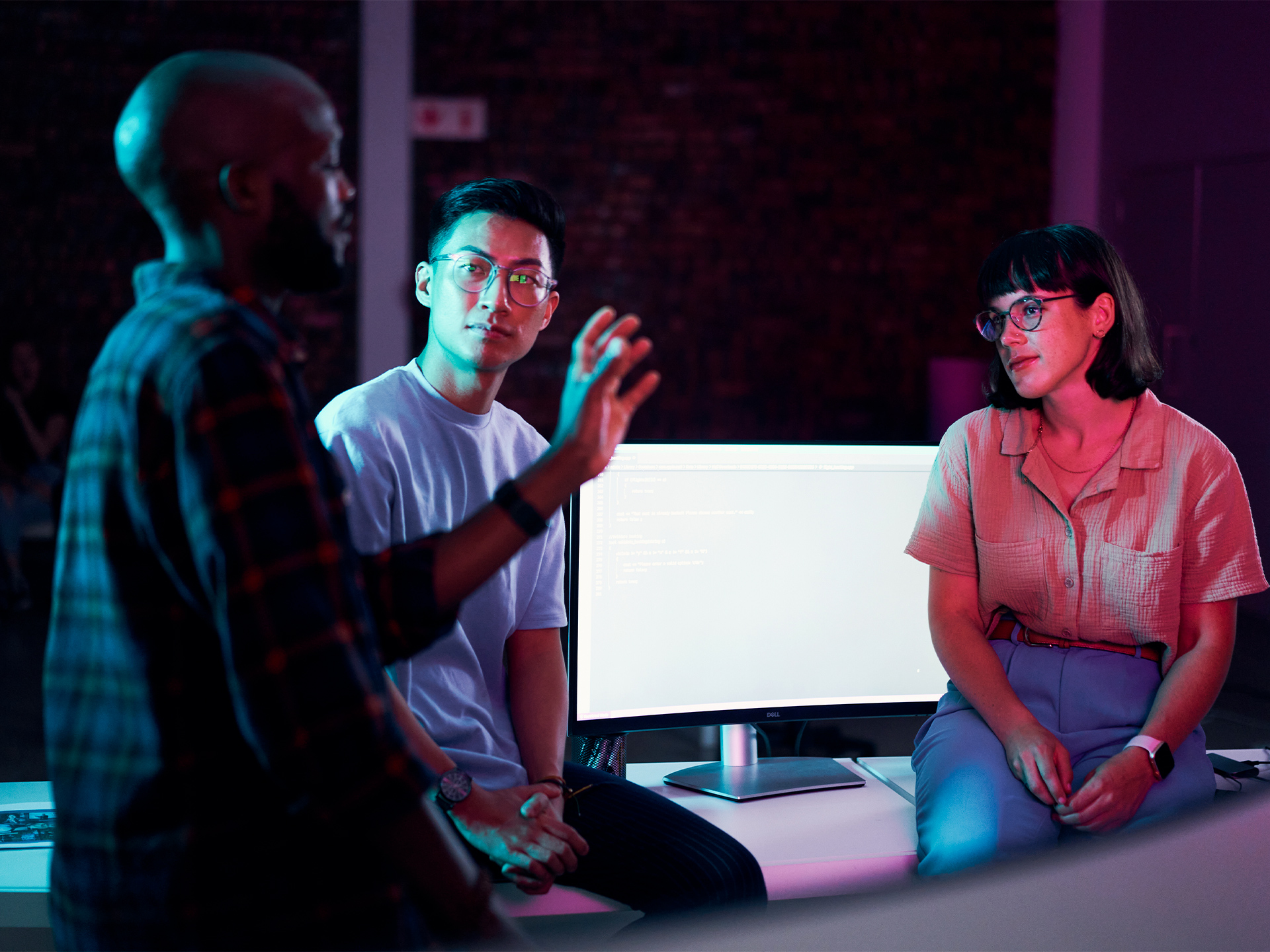 IT team collaborating on tablet in modern workspace
