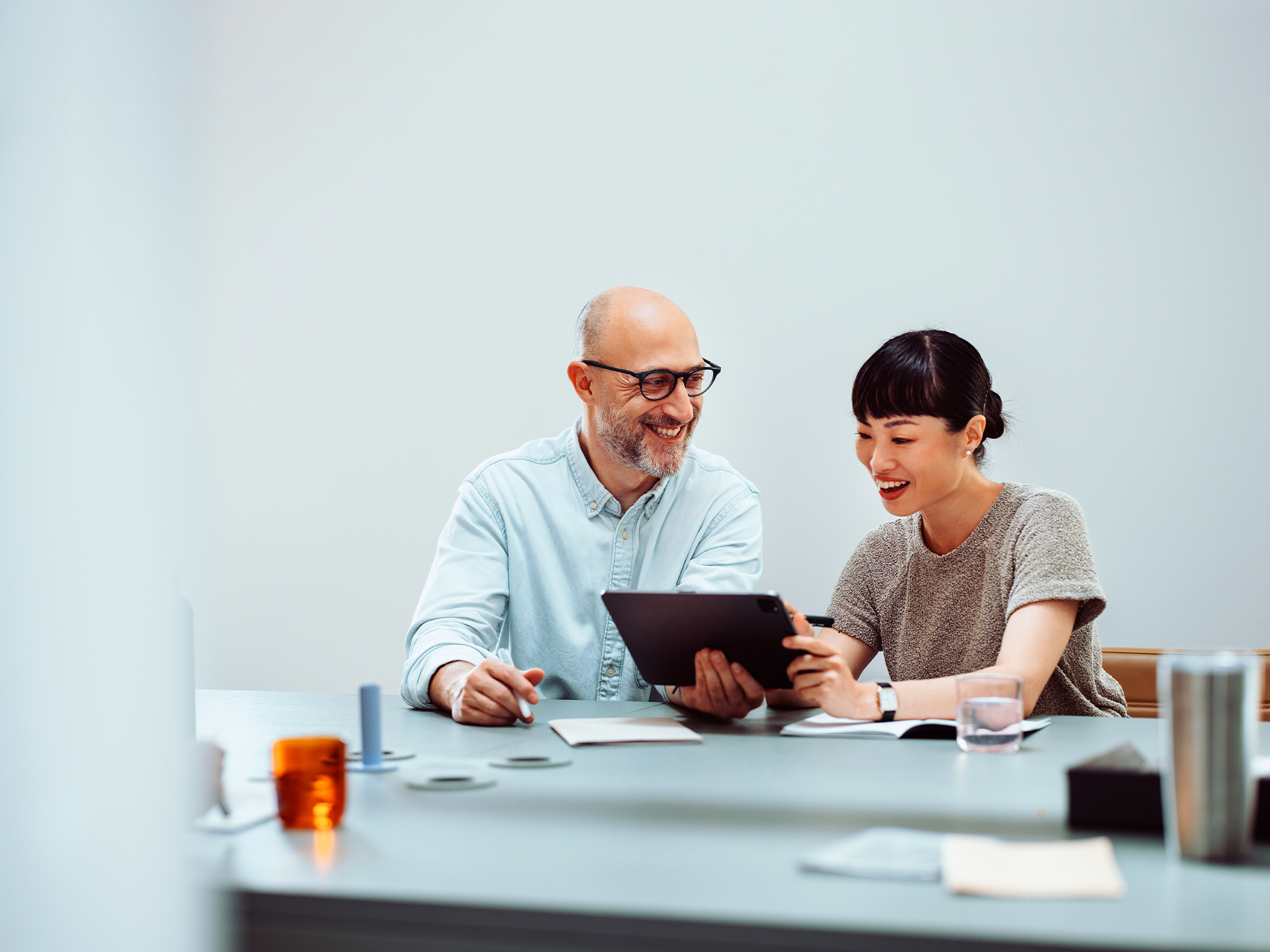 Two people working together using tablet at desk