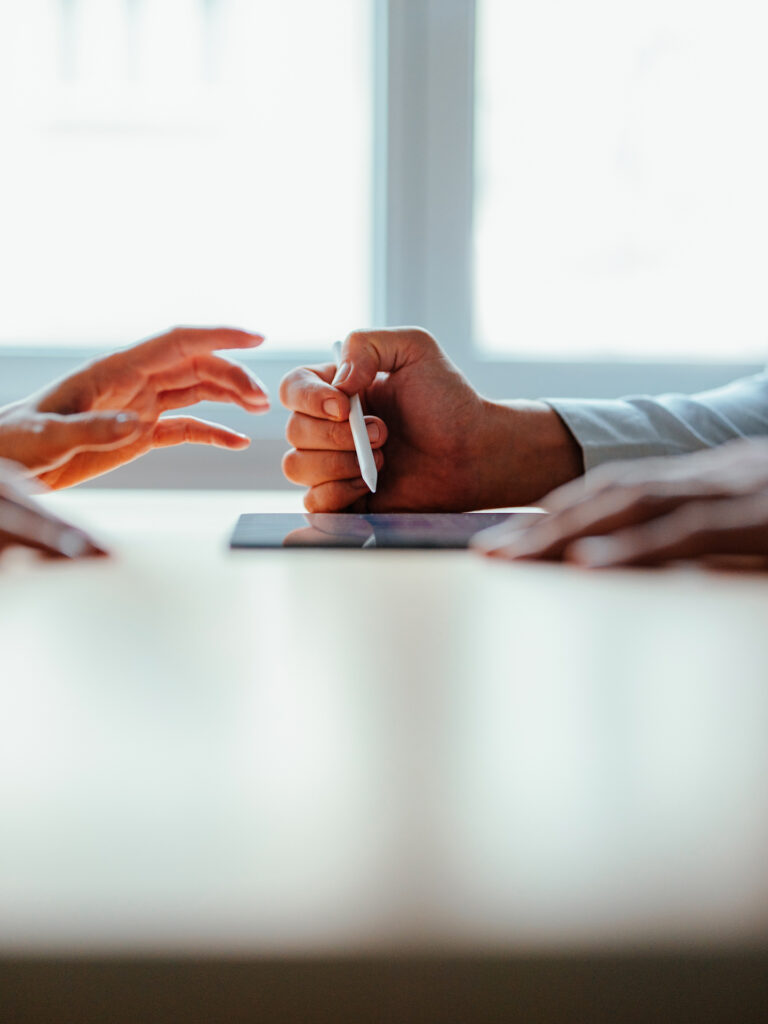 Hands signing document during business meeting