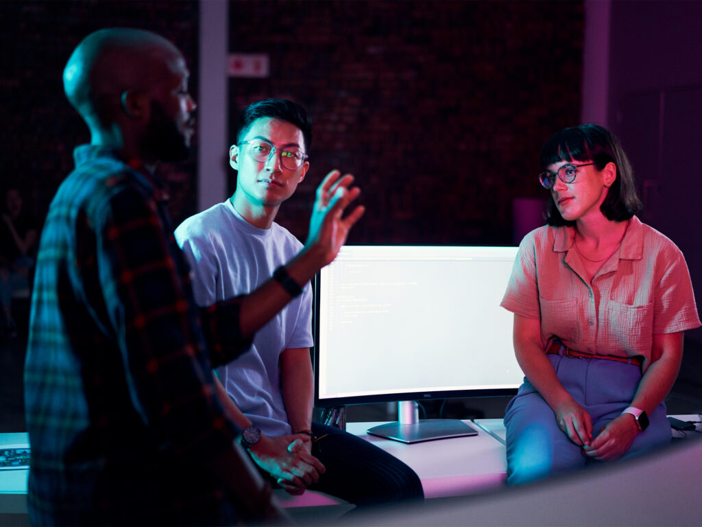 IT team collaborating on tablet in modern workspace