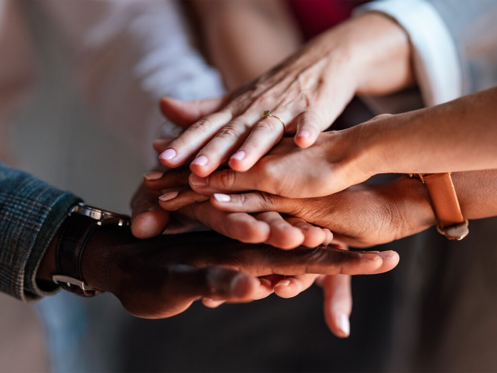 hands stacked together symbolizing teamwork and unity